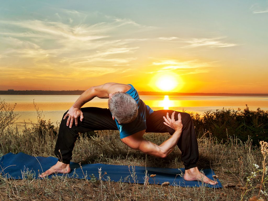 Yoga Athlete performing asana at sunset