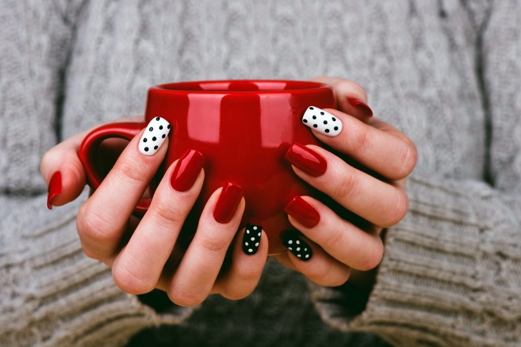 Woman with manicured nails holding a cup